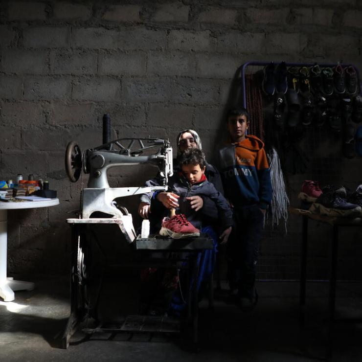 woman sitting behind her sewing machine with her kids 