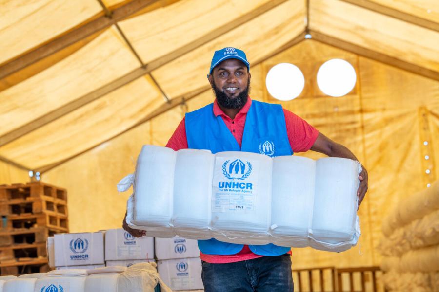 UNHCR Staff carrying relief items. 