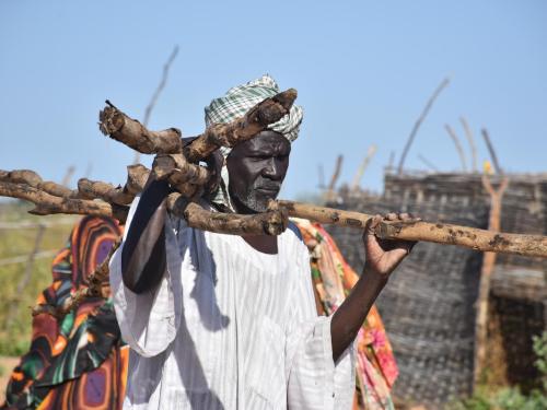 man carrying building poles