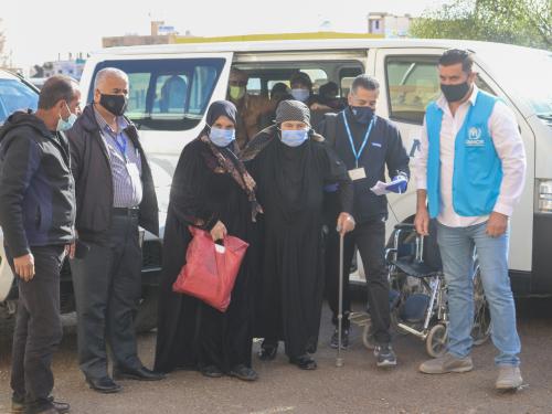 UNHCR staff helping a woman