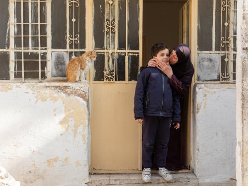 A mother kisses her young son's cheek.