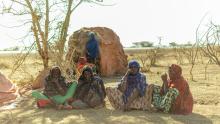 Ethiopian women sitting on the ground in a desert thinking 