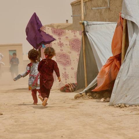 Children run for shelter from high winds and dust in Nawabad Farabi-ha camp for IDPs in Mazar-e Sharif, northern Afghanistan. 