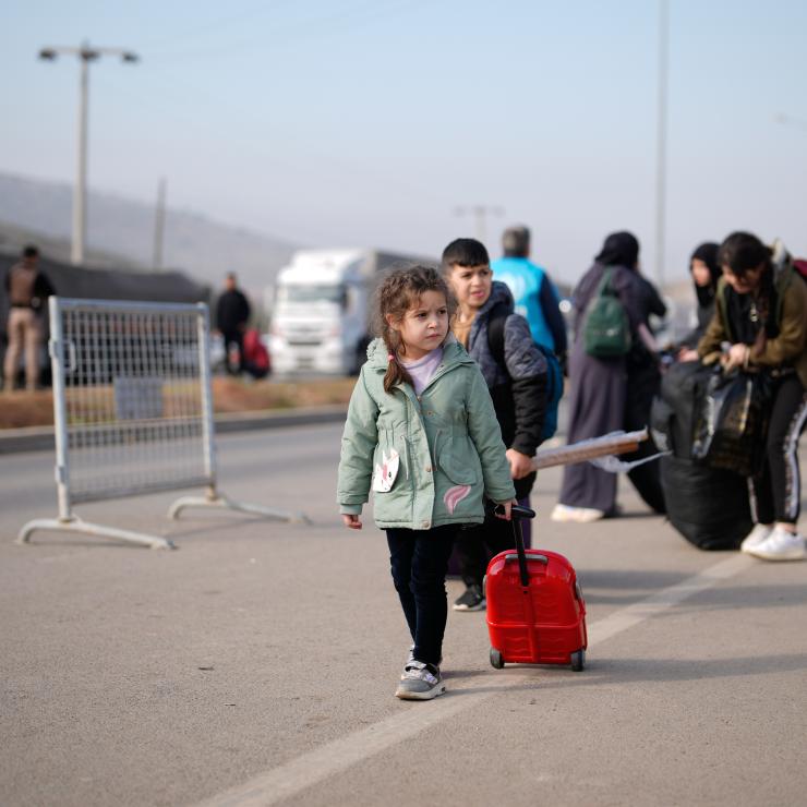 little girl carrying her luggage crossing the border between Türkiye and Syria