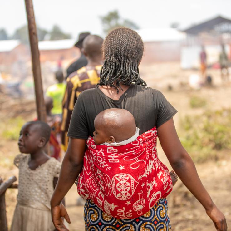 woman walking carrying her baby 