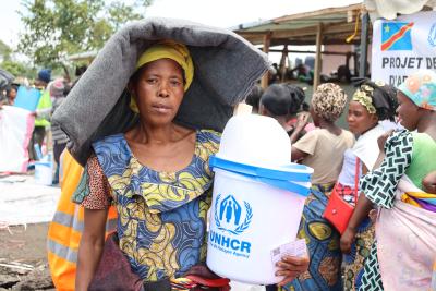 A woman carrying relief items. 