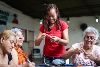 woman showing how to sew to other women