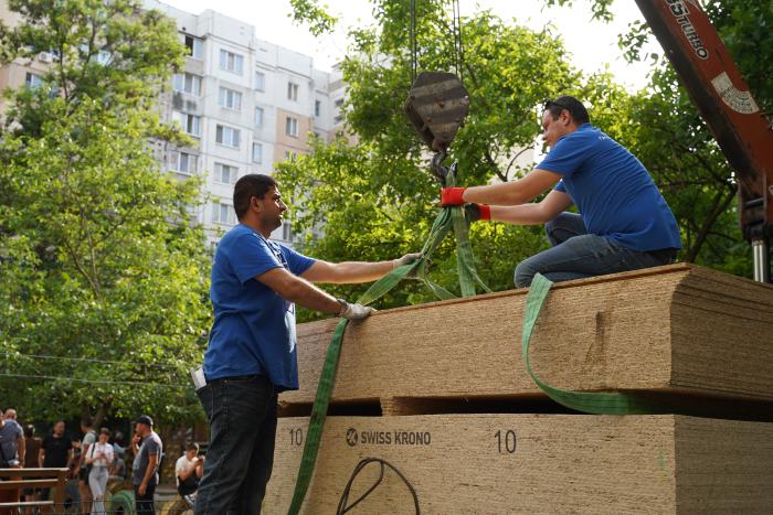 People unloading the building materials from a truck