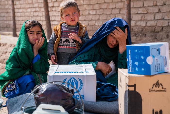 Woman and her children sitting down near their parcels