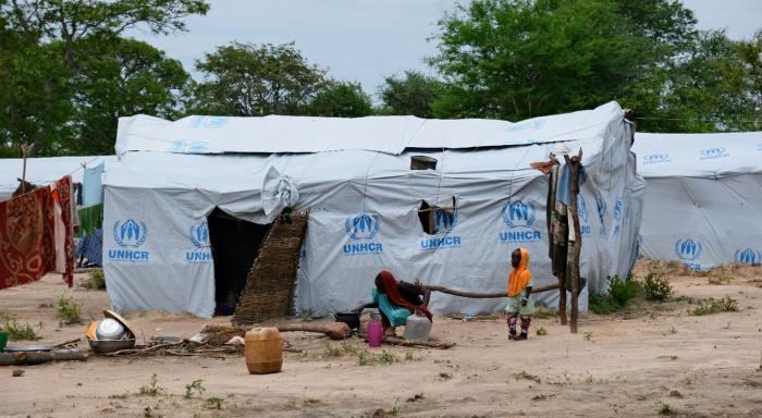 woman and child in front of their temporary shelter