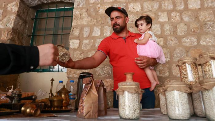 man carrying his daughter running his business