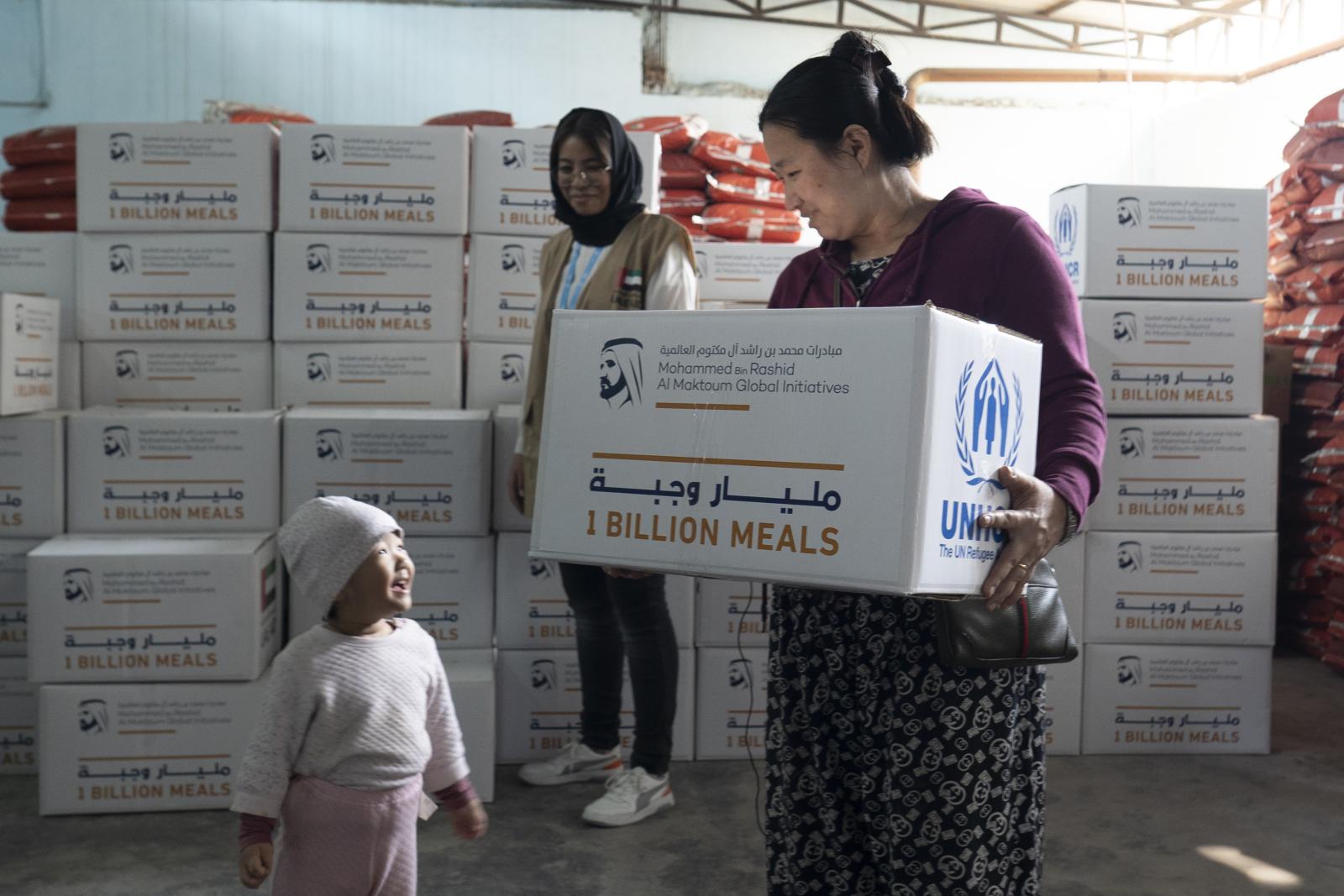 woman carrying a package and looking at a child