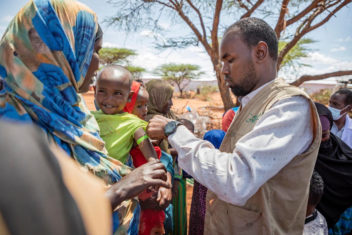 little boy hold by his mum is screened for malnutrition