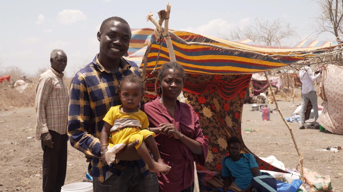 man with his child and wife in the camp