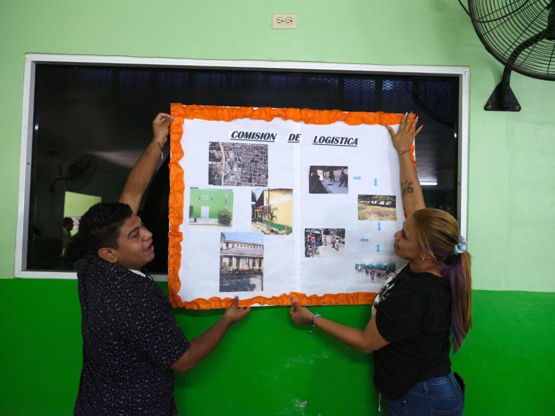 man and woman hanging some workshop outcome on the wall