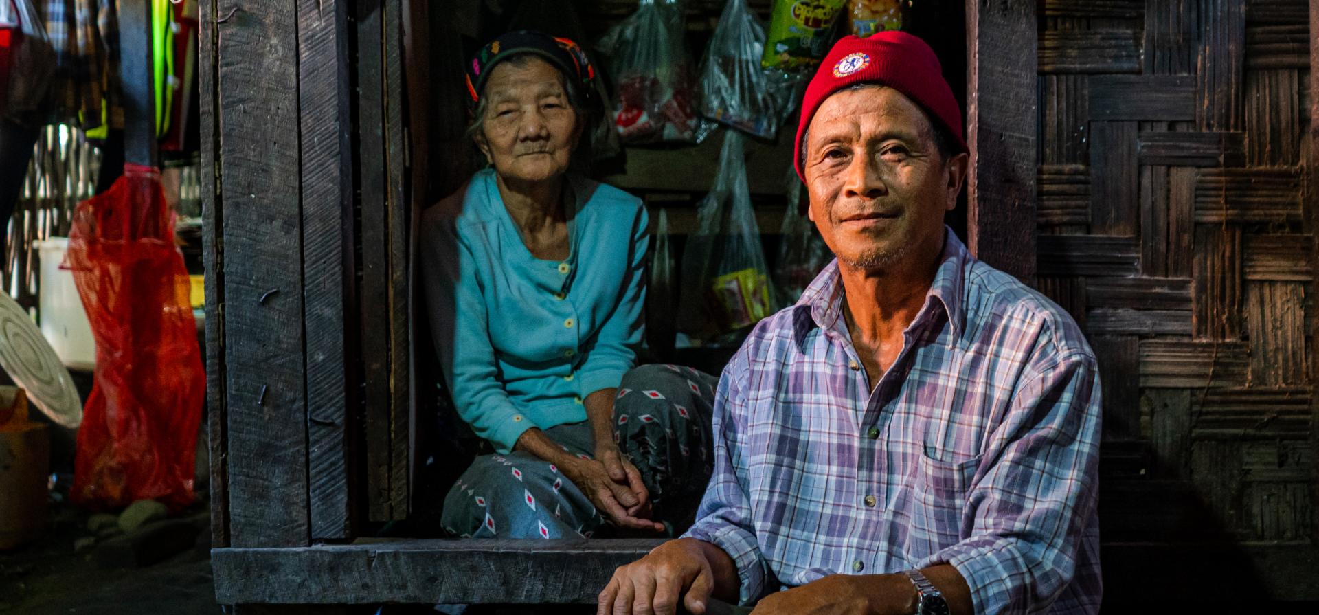 Zau Mun, 62, stands next to his shelter in an IDP camp in North-East Myanmar. He was able to find small jobs inside and outside of the camp to provide food for his family. © UNHCR/Dumhpau Hkunring
