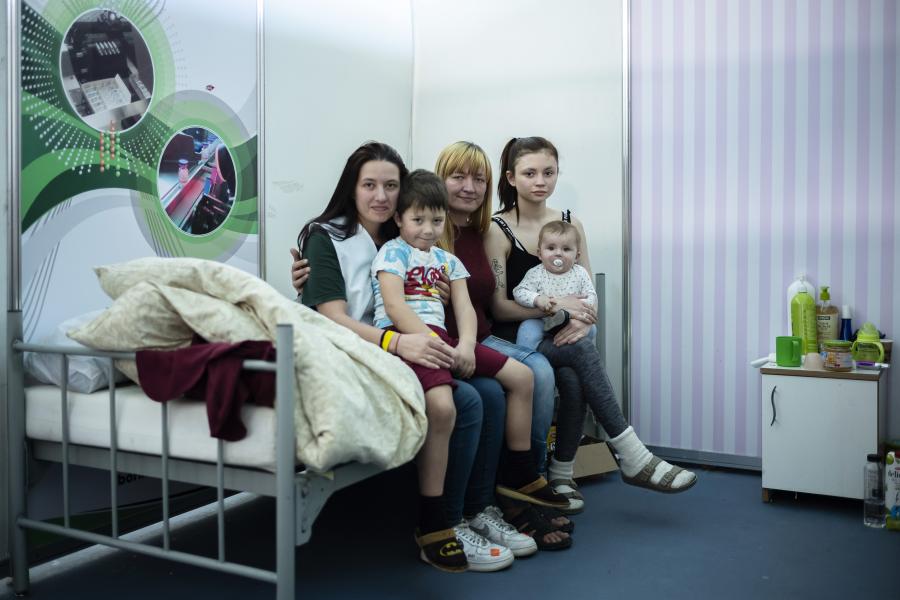 Family portrait. Viktoria Tytarenko, 26 years old, is seating on a bed accompanied by her mother, her sister, her son, and her nephew.