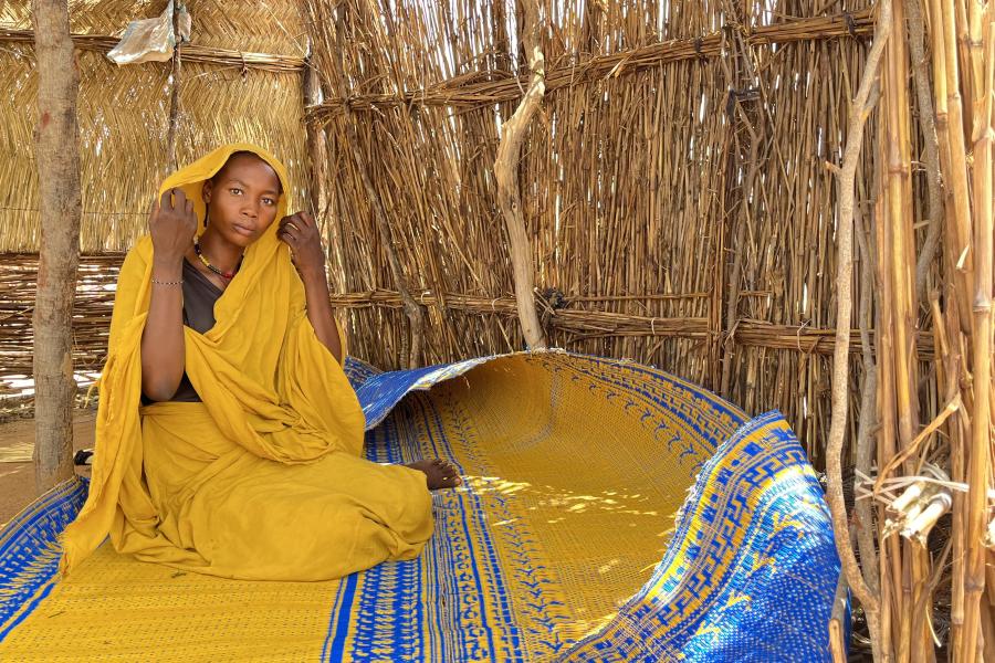 woman dressed with a yellow dress repairing from the sun in a shelter