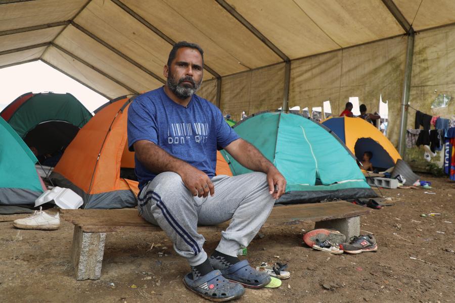 A man sitting down under a tent