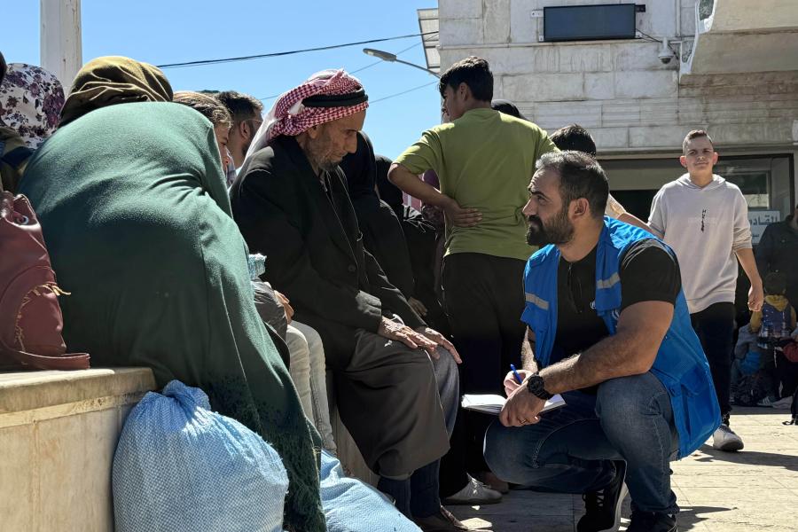 staff talking to a man sitting