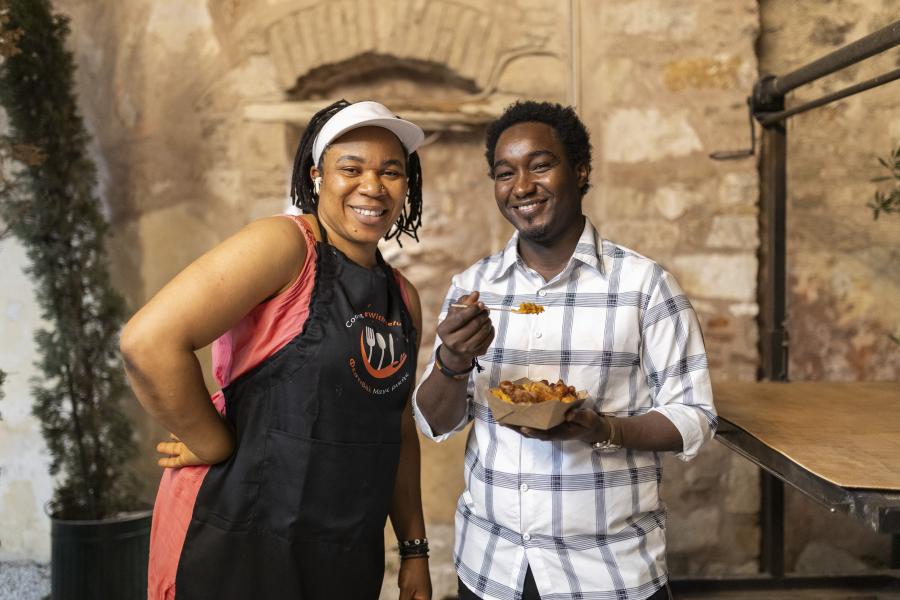 two people standing in a kitchen