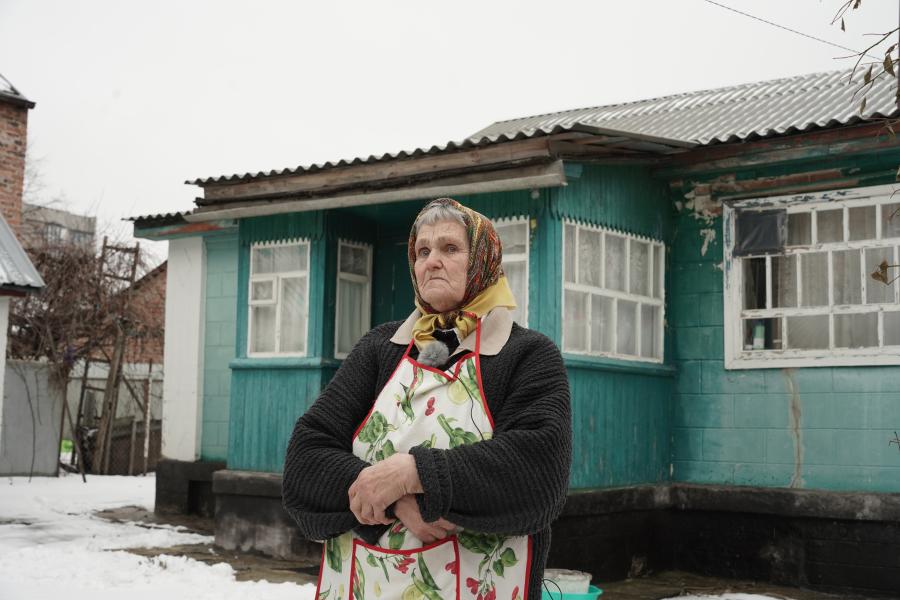 Ukrainian woman standing in front of her house
