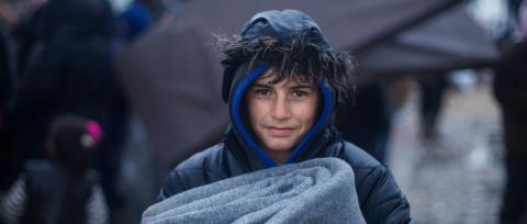 A young boy in Syria holding a warm blanket.