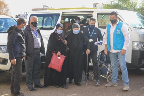 UNHCR staff helping a woman
