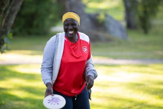Nakout laughs as she takes her stance before throwing a frisbee.