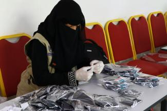 A woman labels the COVID-19 face masks in Ibb governorate, Yemen.