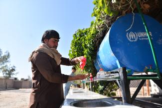 Muhabat Khan, 21, a returnee uses a handwashing station, installed to prevent COVID-19 transmission in Sheikh Misri New Township, Nangarhar, Afghanistan.