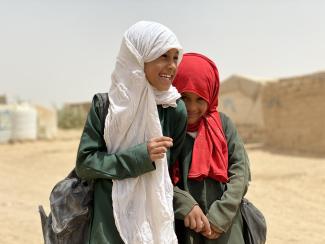 Nine-year-old Shaima’a (left) gets ready to leave for school from the mud house that her parents sold their jewellery to build in one of the 83 hosting sites for internally displaced Yemenis in Marib.