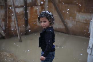 Aisha stands in the snow in front of her flooded tent in an informal refugee settlement in Lebanon’s Bekaa Valley, which is home to more than 215,000 Syrian refugees.