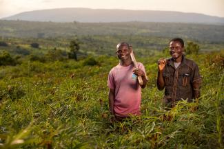 two men cultivating in a field smiling