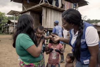 woman chatting and holding a baby hand