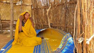 woman sitting in a temporary shelter 