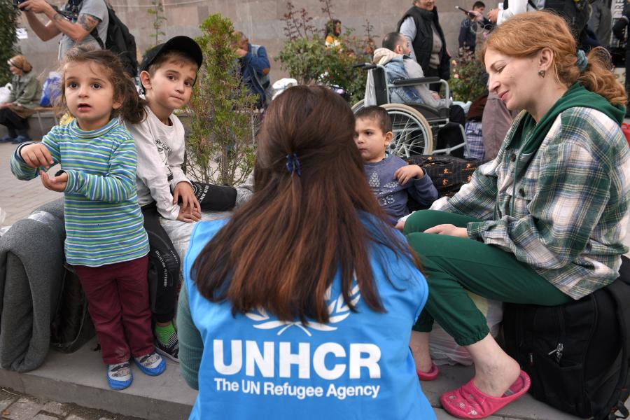 UNHCR staff with sitting down with children and their parents
